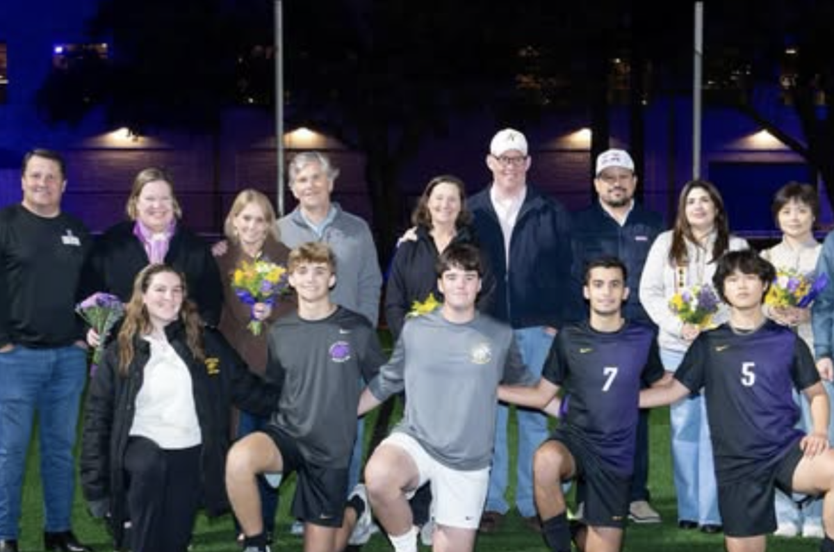 Senior boys varsity soccer players pose with their parents during Senior Night